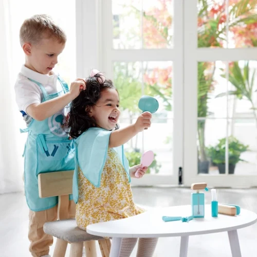 Niños jugando con el juego de peluquería superelegante de Hape