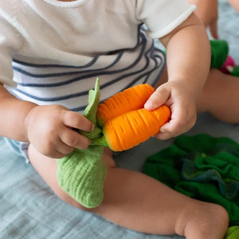 Cathy the Carrot Mini Doudou-Teether niño jugando
