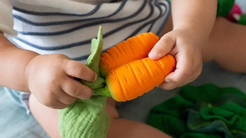 Cathy the Carrot Mini Doudou-Teether niño jugando